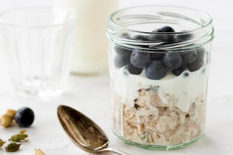 a jar of oats, blueberries, and milk